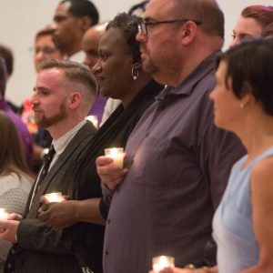 Congregation of people holding candles.