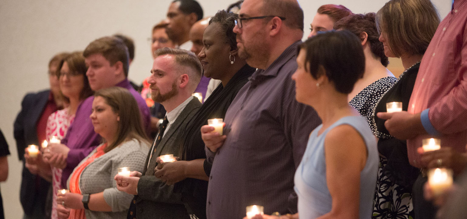 Congregation of people holding candles.