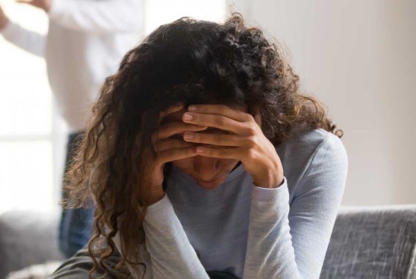 person sitting on a couch with their head in their hands